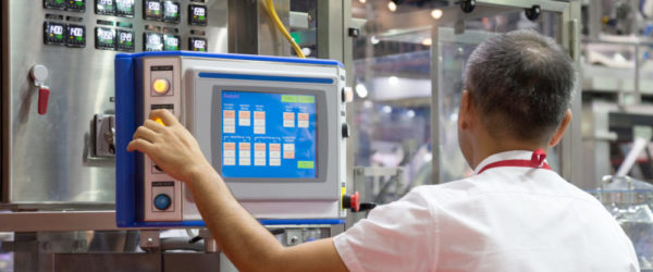 factory engineer controlling and pressing important technology button at control panel of an automatic machine in the manufacturing.